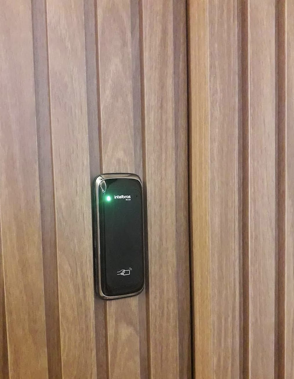 Leitor de cartão de fechadura eletrônica instalado em porta de madeira